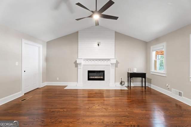 unfurnished living room with a ceiling fan, wood finished floors, a fireplace, lofted ceiling, and baseboards