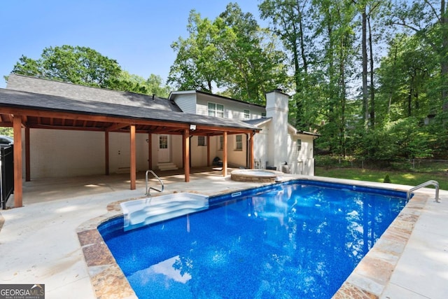 outdoor pool with a patio area and an outdoor hot tub