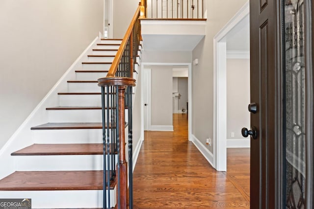 entryway featuring wood finished floors, stairway, and baseboards