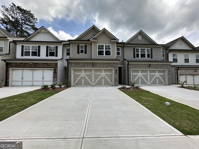 multi unit property featuring board and batten siding, an attached garage, and driveway