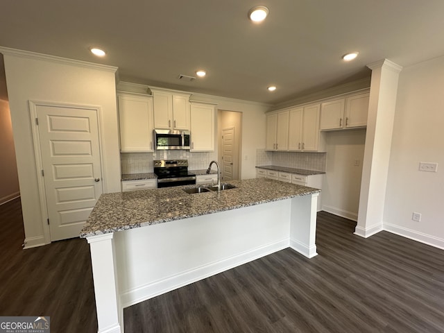 kitchen featuring stainless steel appliances, a sink, dark wood finished floors, baseboards, and recessed lighting