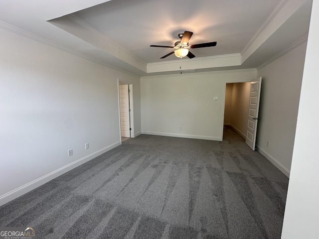 carpeted empty room featuring a raised ceiling, crown molding, a ceiling fan, and baseboards