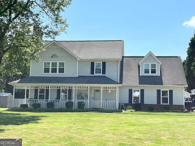 view of front facade featuring covered porch, a front yard, and roof with shingles