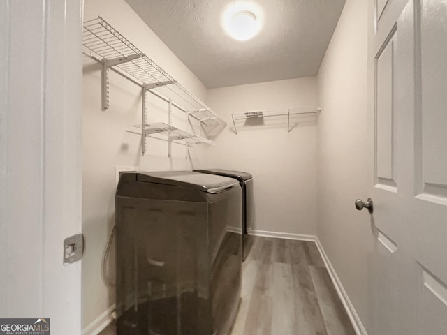6001 Deer Springs Ln NW, Acworth, GA 30101 - laundry room featuring washing machine and dryer, wood finished floors, baseboards, and a textured ceiling