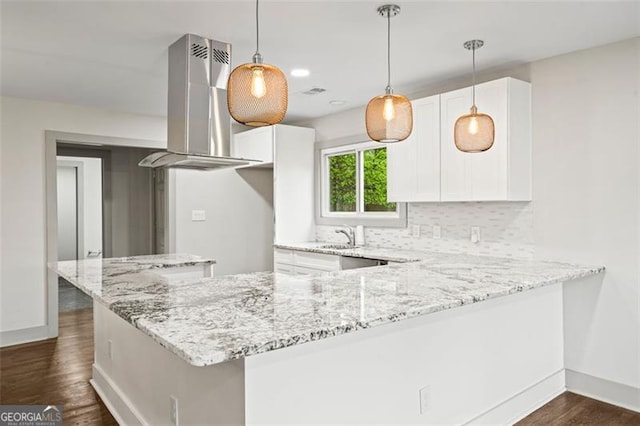 664 Florence Pl NW, Atlanta, GA 30318 - kitchen with wall chimney exhaust hood, light stone countertops, dark wood-type flooring, and white cabinetry