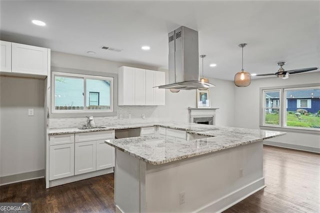 664 Florence Pl NW, Atlanta, GA 30318 - kitchen featuring island exhaust hood, white cabinets, plenty of natural light, and recessed lighting