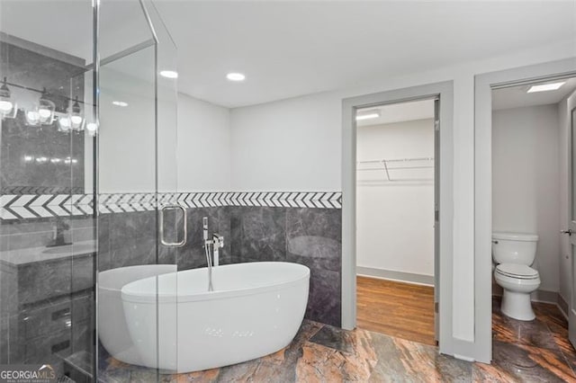 664 Florence Pl NW, Atlanta, GA 30318 - bathroom with a soaking tub, a stall shower, toilet, tile walls, and a spacious closet