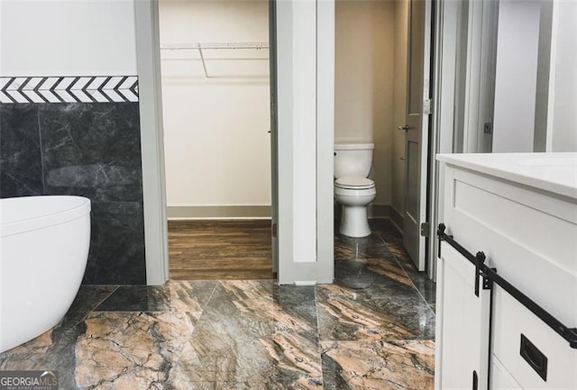 664 Florence Pl NW, Atlanta, GA 30318 - full bath with toilet, vanity, a walk in closet, and baseboards