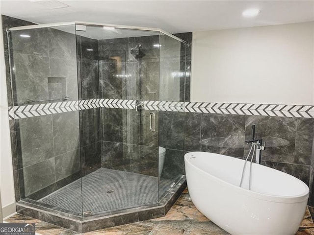 664 Florence Pl NW, Atlanta, GA 30318 - bathroom featuring a shower stall, a soaking tub, and tile walls