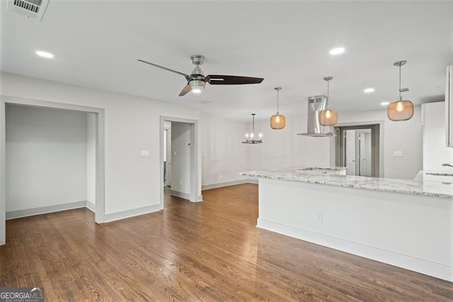 664 Florence Pl NW, Atlanta, GA 30318 - kitchen with wall chimney range hood, ceiling fan, light stone counters, recessed lighting, and white cabinets