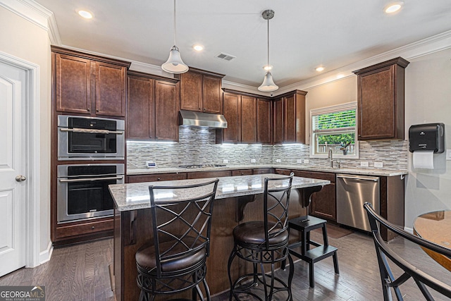 4815 Edgemoore Trce, Cumming, GA 30040 - kitchen with stainless steel appliances, dark wood-style flooring, under cabinet range hood, light stone counters, and ornamental molding