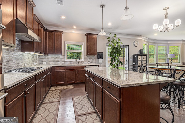 4815 Edgemoore Trce, Cumming, GA 30040 - kitchen featuring stainless steel gas cooktop, under cabinet range hood, a kitchen island, a breakfast bar, and a chandelier