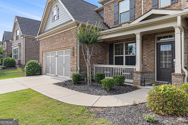 4815 Edgemoore Trce, Cumming, GA 30040 - property entrance featuring a porch, driveway, brick siding, a lawn, and an attached garage