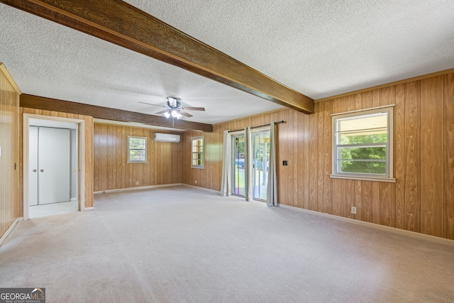 1766 Washington Hwy, Elberton, GA 30635 - unfurnished room with a textured ceiling, wood walls, plenty of natural light, a ceiling fan, and light colored carpet