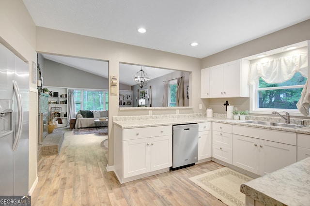 29 Clark Pl, Whitesburg, GA 30185 - kitchen with stainless steel appliances, a sink, a chandelier, white cabinets, and light wood finished floors