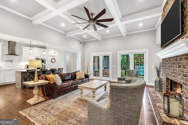 377 Parker Rd, Mcdonough, GA 30252 - living room featuring coffered ceiling, a ceiling fan, beam ceiling, a brick fireplace, and dark wood-style floors