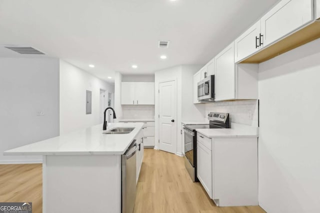 2765 Ocean Valley Dr, Atlanta, GA 30349 - kitchen with stainless steel appliances, a sink, light wood finished floors, a center island with sink, and recessed lighting