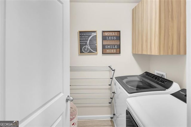 104 Auburn Xing, Auburn, GA 30011 - washroom with independent washer and dryer, cabinet space, and light wood-style floors