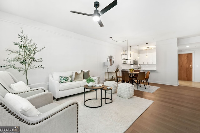 273 12th St NE Unit 114, Atlanta, GA 30309 - living area with wood finished floors, a ceiling fan, baseboards, and a chandelier