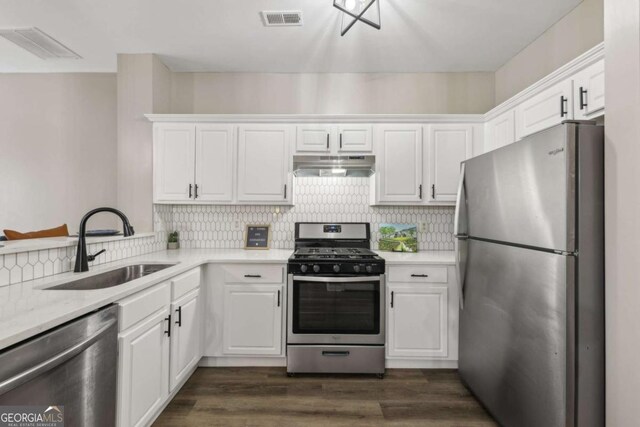 7077 Biltmore Trce, Lithonia, GA 30058 - kitchen with stainless steel appliances, under cabinet range hood, and white cabinetry