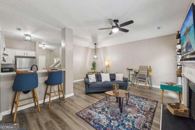 7077 Biltmore Trce, Lithonia, GA 30058 - living room with a fireplace, ceiling fan, and wood finished floors