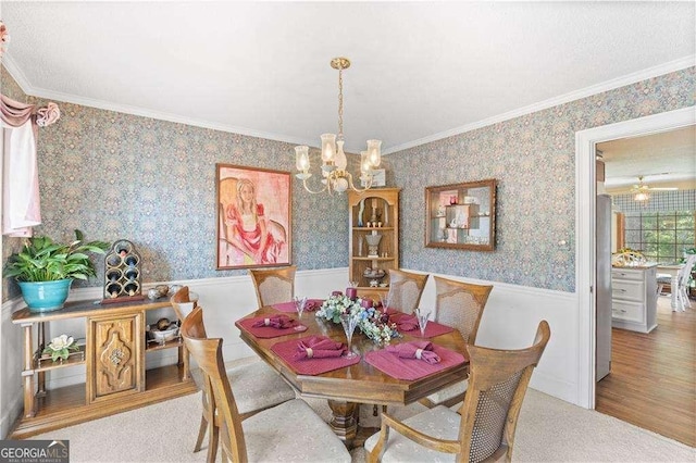 3472 Honeycomb Dr SE, Conyers, GA 30094 - dining space featuring wainscoting, a chandelier, ornamental molding, wallpapered walls, and wood finished floors