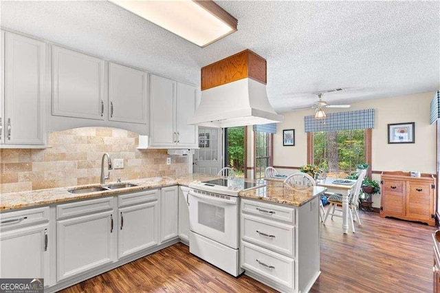 3472 Honeycomb Dr SE, Conyers, GA 30094 - kitchen with a sink, electric stove, ceiling fan, a peninsula, and a textured ceiling
