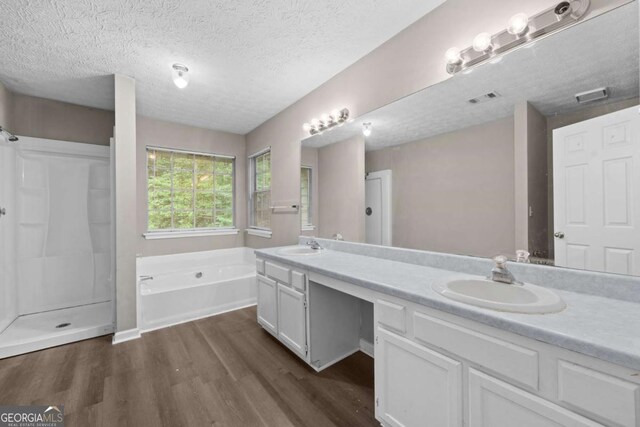 470 Piney Way SW, Atlanta, GA 30331 - bathroom with wood finished floors, a garden tub, double vanity, a textured ceiling, and a shower