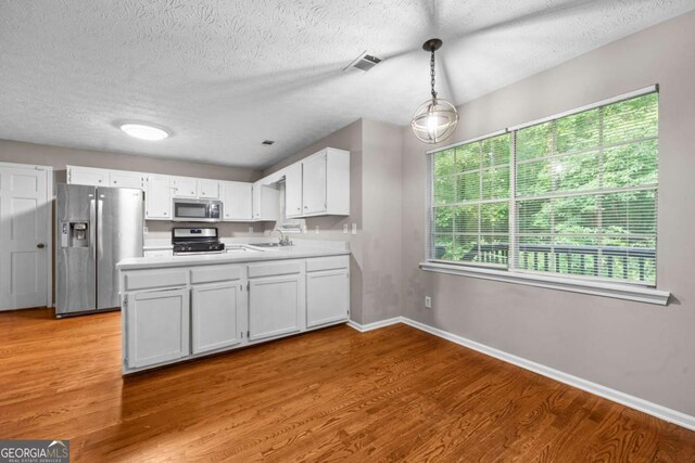 470 Piney Way SW, Atlanta, GA 30331 - kitchen featuring stainless steel appliances, a peninsula, light wood-style flooring, a sink, and a textured ceiling