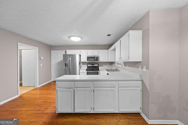 470 Piney Way SW, Atlanta, GA 30331 - kitchen featuring appliances with stainless steel finishes, a sink, a peninsula, baseboards, and light countertops