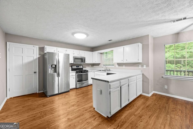 470 Piney Way SW, Atlanta, GA 30331 - kitchen featuring appliances with stainless steel finishes, a sink, a peninsula, baseboards, and a textured ceiling