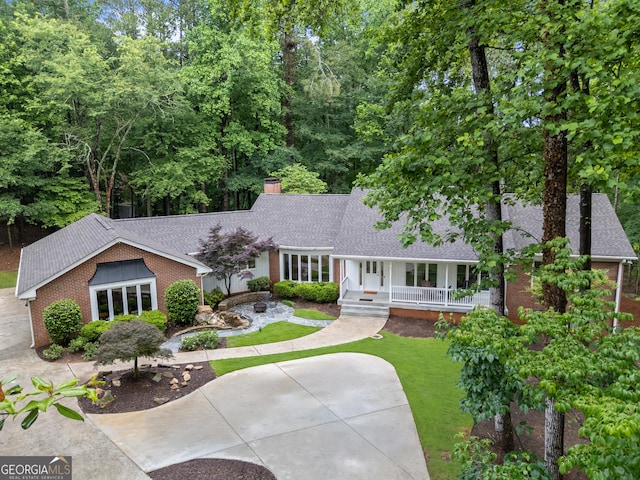 630 Buttercup Trce, Alpharetta, GA 30022 - view of front of house featuring a shingled roof, a porch, brick siding, a chimney, and a front yard