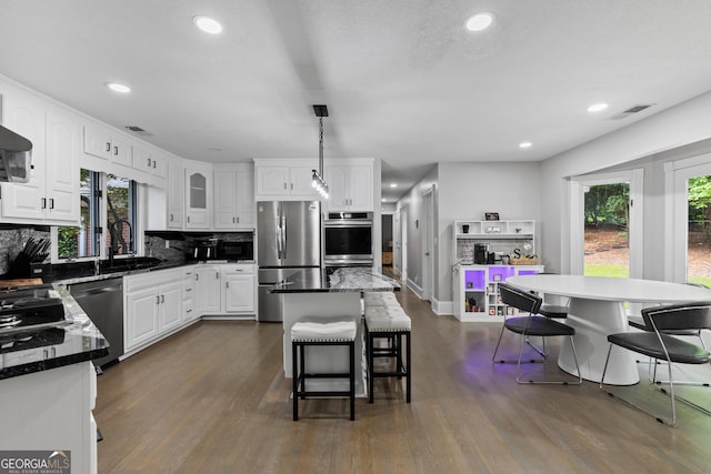 630 Buttercup Trce, Alpharetta, GA 30022 - kitchen featuring appliances with stainless steel finishes, a breakfast bar area, a sink, a center island, and white cabinetry
