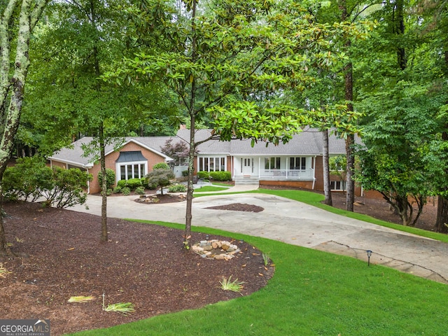630 Buttercup Trce, Alpharetta, GA 30022 - view of front of house featuring curved driveway, brick siding, covered porch, and a front yard