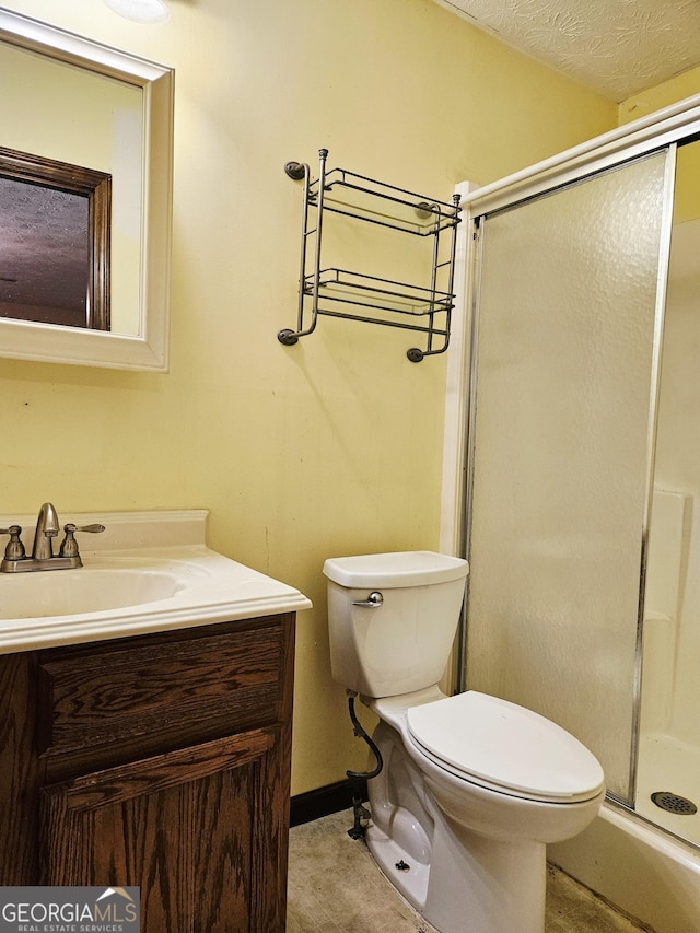 6698 Cameron Rd, Morrow, GA 30260 - bathroom featuring a shower stall, vanity, toilet, and a textured ceiling