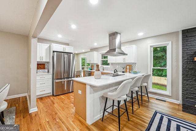 2771 Smithsonia Way, Tucker, GA 30084 - kitchen featuring stainless steel appliances, island exhaust hood, a kitchen bar, a peninsula, and tasteful backsplash