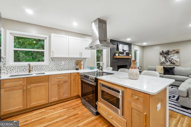 2771 Smithsonia Way, Tucker, GA 30084 - kitchen with a sink, appliances with stainless steel finishes, island range hood, open floor plan, and light wood-style floors