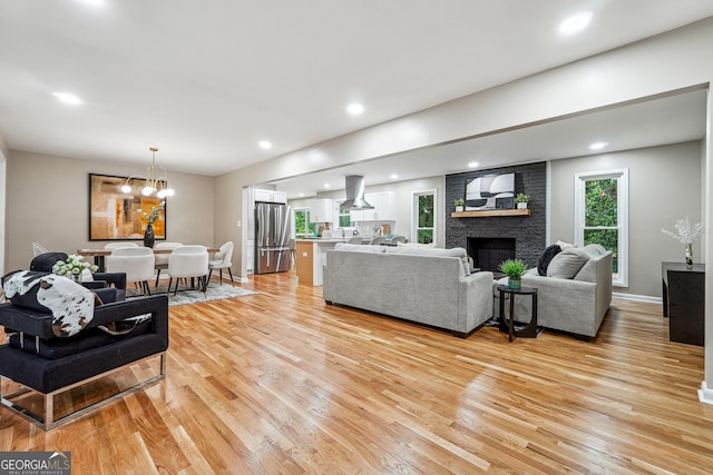 2771 Smithsonia Way, Tucker, GA 30084 - living room featuring light wood-style floors, a fireplace, a chandelier, baseboards, and recessed lighting