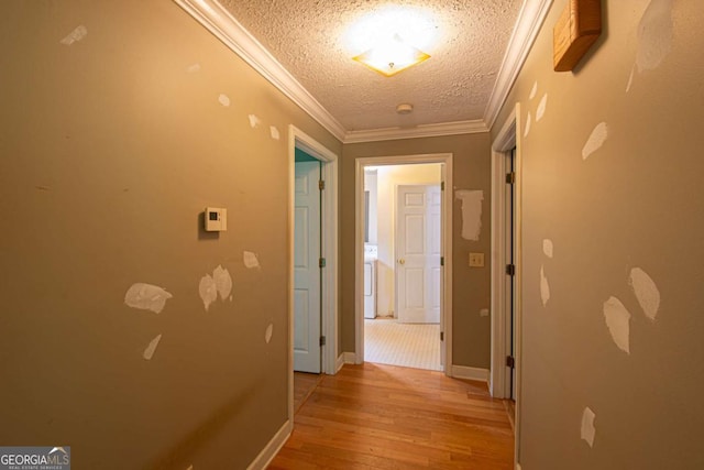 357 Camp Wahsega Rd, Dahlonega, GA 30533 - hall featuring light wood-style flooring, a textured ceiling, ornamental molding, and washer / clothes dryer