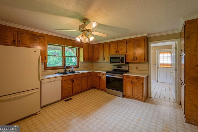 357 Camp Wahsega Rd, Dahlonega, GA 30533 - kitchen featuring appliances with stainless steel finishes, brown cabinets, light countertops, plenty of natural light, and crown molding