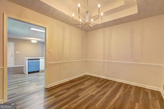 221 Ashley Oaks Dr, Mcdonough, GA 30253 - unfurnished room with dark wood finished floors, a raised ceiling, baseboards, a textured ceiling, and a chandelier
