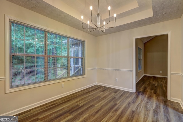 221 Ashley Oaks Dr, Mcdonough, GA 30253 - empty room with wood finished floors, a chandelier, baseboards, a tray ceiling, and a textured ceiling