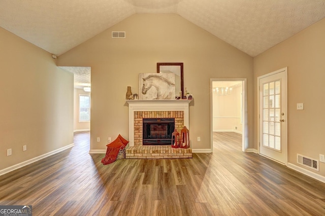 221 Ashley Oaks Dr, Mcdonough, GA 30253 - unfurnished living room featuring wood finished floors, a fireplace, high vaulted ceiling, baseboards, and a textured ceiling