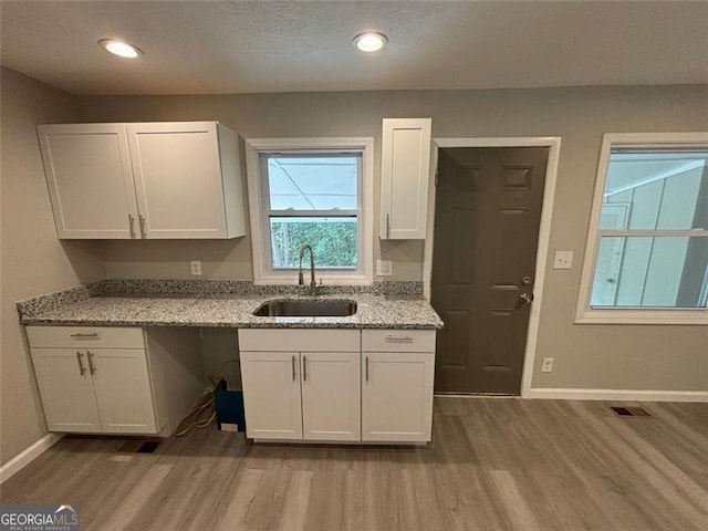 2489 Hillside Dr, Macon, GA 31206 - kitchen featuring a sink, wood finished floors, white cabinetry, baseboards, and recessed lighting