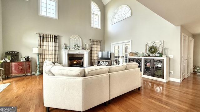 297 Old Clarkesville Mill Rd, Clarkesville, GA 30523 - living room featuring wood finished floors, a towering ceiling, a tile fireplace, baseboards, and french doors