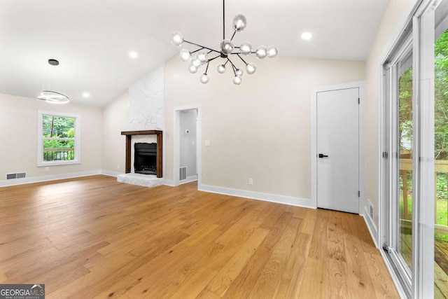 4043 Chedworth Way, Stone Mountain, GA 30083 - unfurnished living room featuring lofted ceiling, a chandelier, light wood-style flooring, a fireplace, and baseboards