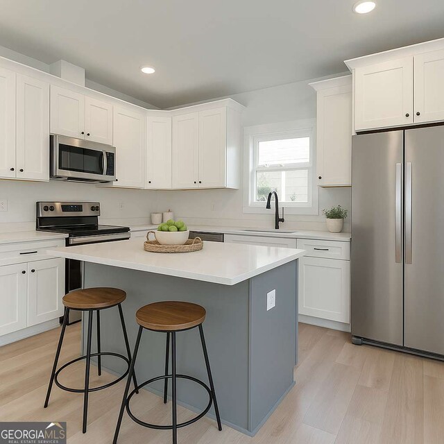 3110 Granada Way, Gainesville, GA 30506 - kitchen featuring appliances with stainless steel finishes, a kitchen breakfast bar, a kitchen island, white cabinetry, and light countertops