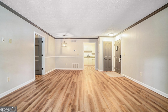 328 Bentley Pl Unit 328, Tucker, GA 30084 - unfurnished living room featuring crown molding, light wood-type flooring, a textured ceiling, and baseboards