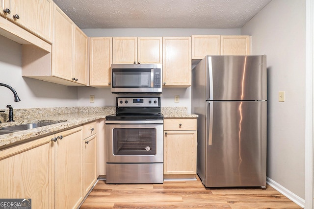 328 Bentley Pl Unit 328, Tucker, GA 30084 - kitchen featuring appliances with stainless steel finishes, light brown cabinets, a sink, and light wood-type flooring