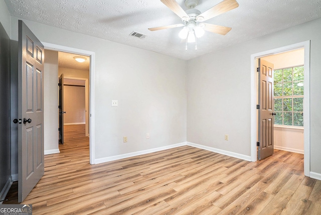 328 Bentley Pl Unit 328, Tucker, GA 30084 - unfurnished bedroom with light wood finished floors, baseboards, a textured ceiling, and ceiling fan